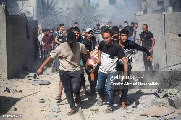 Palestinian emergency services and local citizens carry a victim of Israeli air raids in the southern Gaza Strip on October 18, 2023 in Khan Yunis,...