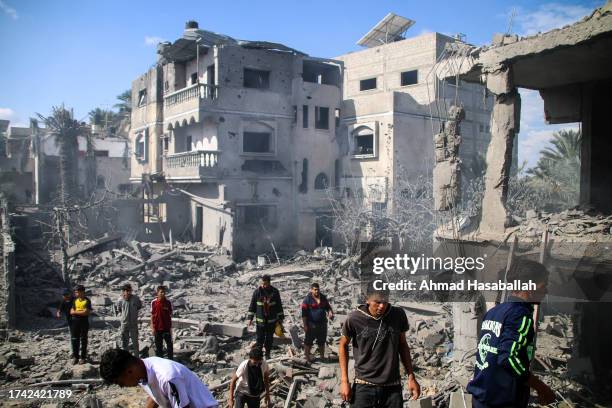 Palestinian emergency services and local citizens search for victims in buildings destroyed during Israeli air raids in the southern Gaza Strip on...