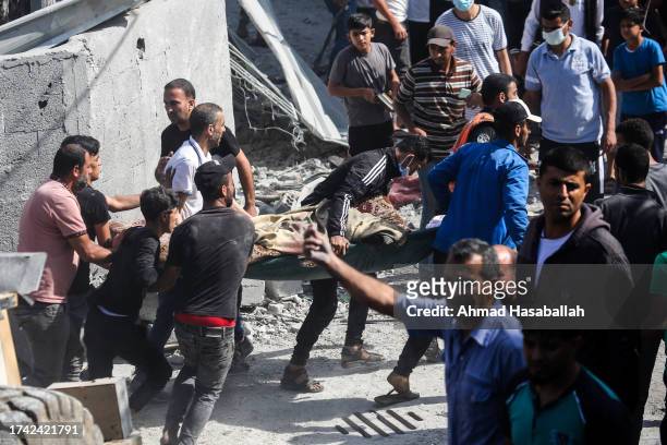 Palestinian emergency services and local citizens carry a victim of Israeli air raids in the southern Gaza Strip on October 18, 2023 in Khan Yunis,...