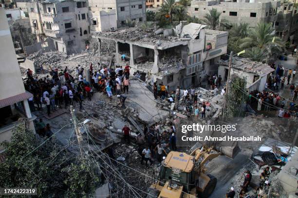 Palestinian emergency services and local citizens search for victims in buildings destroyed during Israeli air raids in the southern Gaza Strip on...