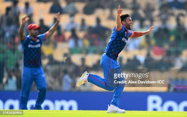 Azmatullah Omarzai of Afghanistan celebrates the wicket of Will Young of New Zealand during the ICC Men's Cricket World Cup India 2023 between New...