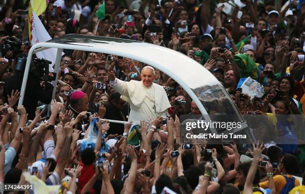Pope Francis waves to the crowd while departing the Metropolitan Cathedral in the Popemobile after arriving in Rio on July 22, 2013 in Rio de...