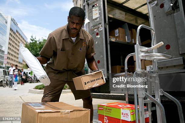United Parcel Service Inc. Employee Mike Hill arranges packages for delivery in Washington, D.C., U.S., on Monday, July 22, 2013. UPS is expected to...
