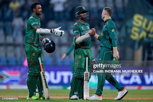 Bangladesh's Mustafizur Rahman greets South Africa's David Miller as his teammate Shoriful Islam watches at the end of the 2023 ICC Men's Cricket...