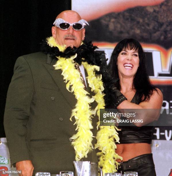 Minnesota Governor and former professional wrestler Jesse Ventura is adorned with his former trademarks, sequined sunglasses and a feather boa, by...