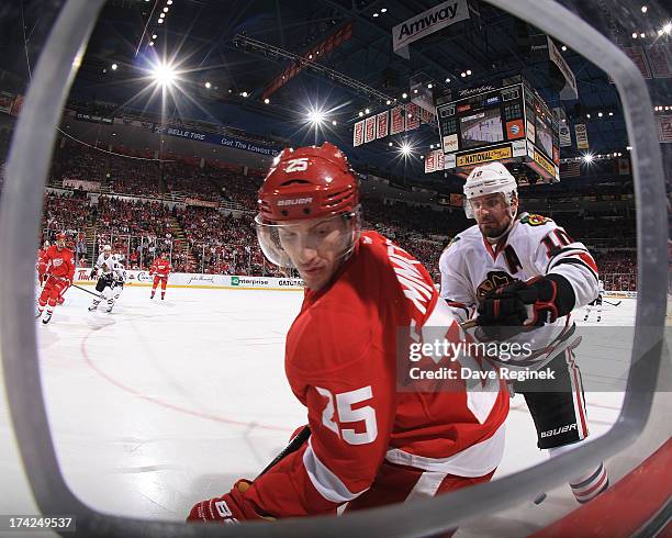 Cory Emmerton of the Detroit Red Wings battles in the corner with Patrick Sharp of the Chicago Blackhawks during Game Four of the Western Conference...