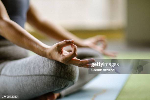 woman in meditation in a half lotus position at a gym - banten stock pictures, royalty-free photos & images