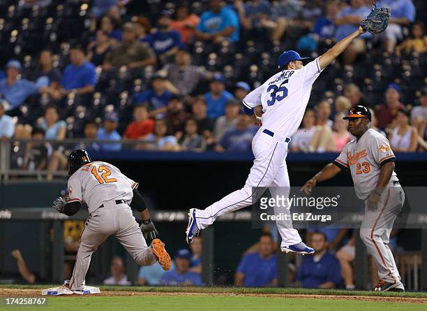 Alexi Casilla of the Baltimore Orioles reaches first for a single as Eric Hosmer of the Kansas City Royals leaps to catch the throw in the ninth...