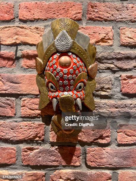 nepali metal ganesha statue decorated on the wall - brick wall brass stock pictures, royalty-free photos & images