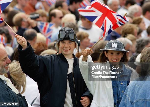 Young boy and girl wearing World War Two outfits and waving Union Jacks celebrating the 50th anniversary of VE-Day on The Mall in London on 6th May...