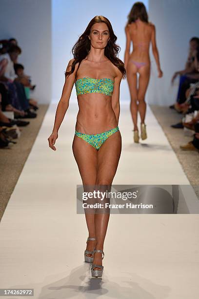 Model walks the runway at the Indah show during Mercedes-Benz Fashion Week Swim 2014 at Cabana Grande at the Raleigh on July 22, 2013 in Miami,...