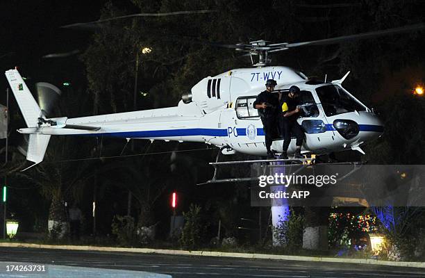 Members of the Algerian police forces aboard an helicopter take part in a show of force ceremony marking the fiftieth anniversary of the General...