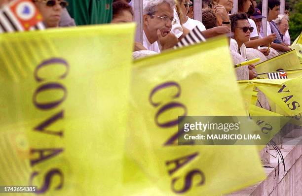 Thousands of followers hold flags 07 March 2001 as Governor Mario Covas' funeral procession passes in the streets of Sao Paulo, Brazil. Miles de...