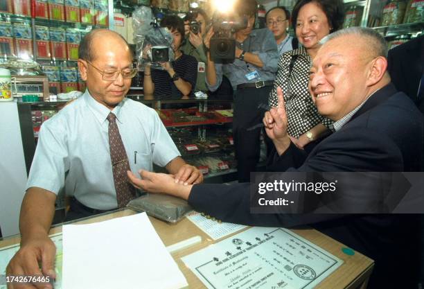 Hong Kong Chief Executive Tun Chee-hwa gets his pulse checked by a herbalist in Hong Kong 04 August 2000. Tung was on a visit to low-income families...