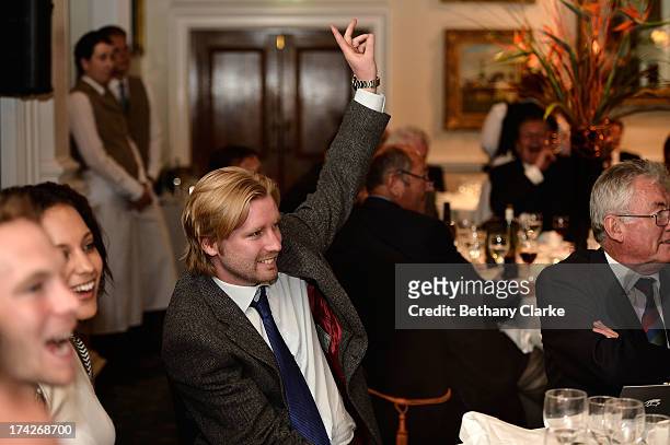 Guests bid in the charity auction during the Gary Player Invitational Europe 2013 Gala Dinner at Wentworth on July 22, 2013 in Virginia Water,...