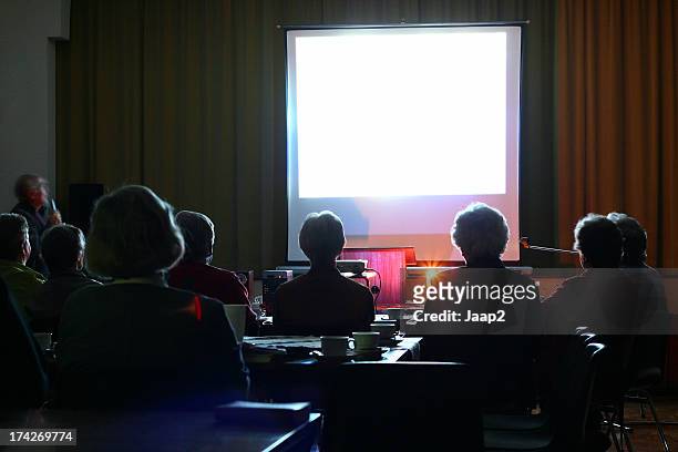 people looking at an evening presentation - cinema projector stock pictures, royalty-free photos & images