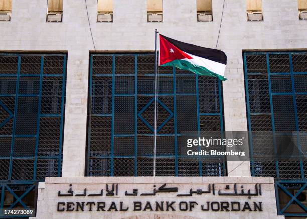 The Jordanian flag flies over the entrance of the Central Bank of Jordan in Amman, Jordan, on Sunday, July 21, 2013. Jordanian internal debt has...