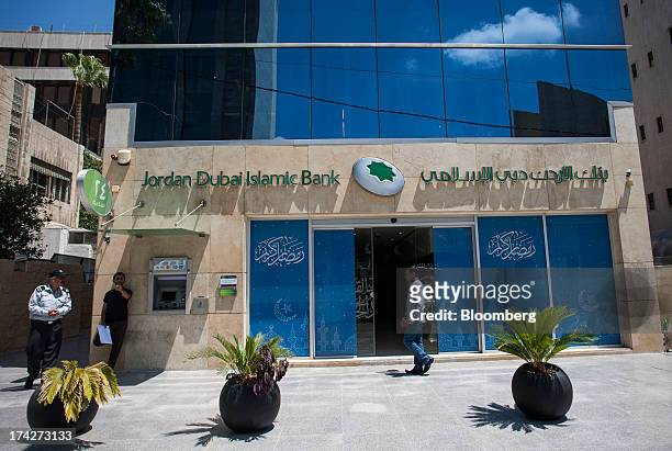 Pedestrian passes a branch of Jordan Dubai Islamic Bank in the financial district in Amman, Jordan, on Sunday, July 21, 2013. Jordanian internal debt...