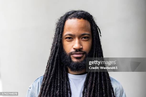 man with long hair in front of white wall - cabello rastafari fotografías e imágenes de stock