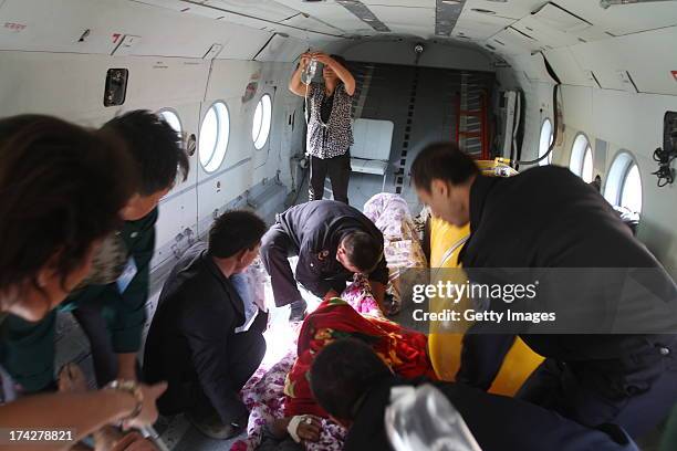 Rescuers carry an injured person onto a helicopter on July 23, 2013 in Minxian, China. At least 89 people were killed and 5 others missing after a...