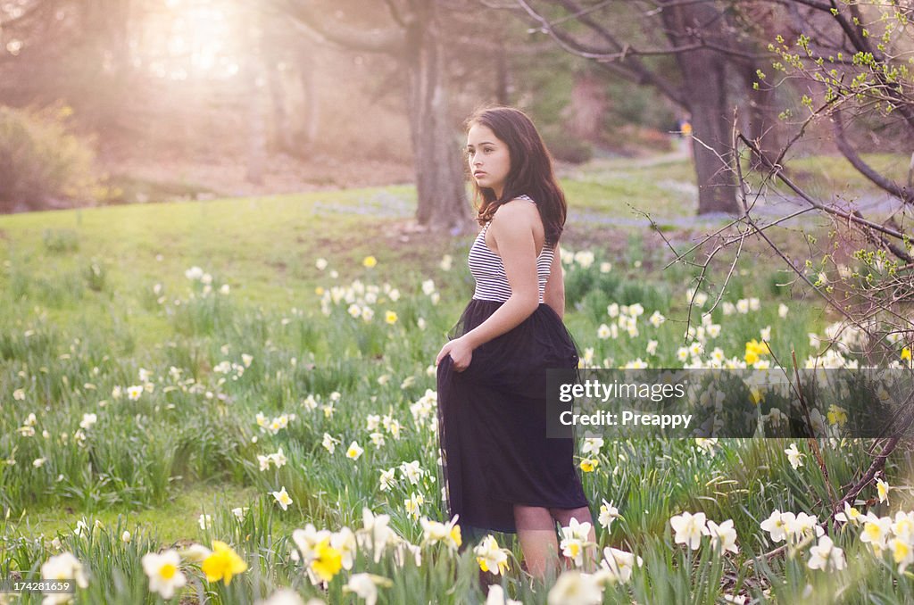 Young girl standing in daffodil field