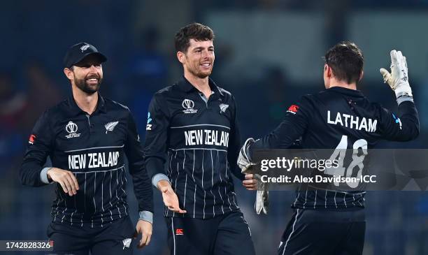 Mitch Santner of New Zealand celebrates the wicket of Fazal Farooqi of Afghanistan with team mates Tom Latham and Devon Conway during the ICC Men's...