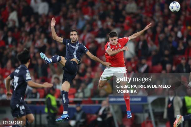 Benfica's Portuguese defender Antonio Silva fights for the ball with Real Sociedad's Spanish midfielder Mikel Merino during the UEFA Champions League...