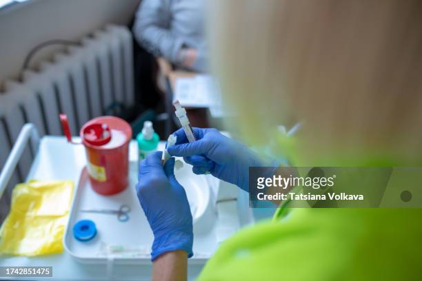 trained hands of unrecognizable medical professional in blue gloves unpack new syringe preparing for instructional demonstration - first aid class stock pictures, royalty-free photos & images