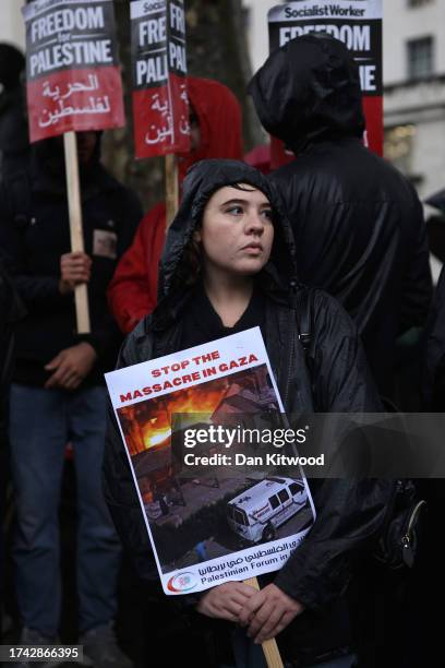 Pro-Palestinian supporter holds a placard that reads "Stop The Massacre In Gaza" as they attend a vigil for the victims of the Al-Ahli Arab Hospital...