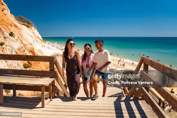 touristen, die vom strand aus treppen steigen - albufeira stock-fotos und bilder