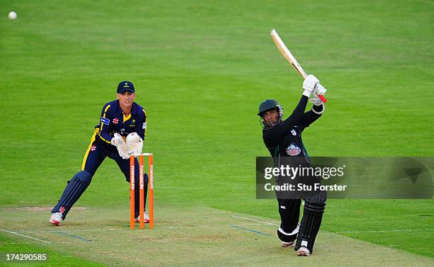 Royals batsman Thilan Samaraweera hits over the top watched by keeper Mark Wallace during the Friends Life T20 match between Glamorgan Dragons and...