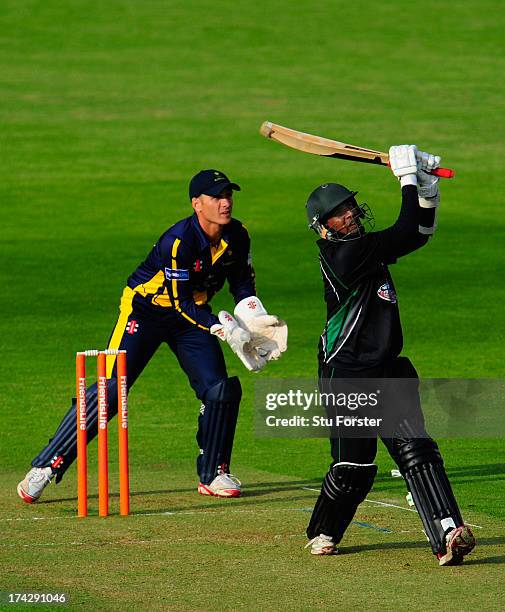 Royals batsman Thilan Samaraweera hits over the top watched by keeper Mark Wallace during the Friends Life T20 match between Glamorgan Dragons and...