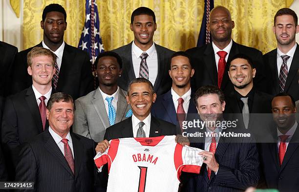 Head coach Rick Pitino presents U.S. President Barack Obama with a basketball jersey from the Louisville Cardinals, the 2013 NCAA Men's Basketball...