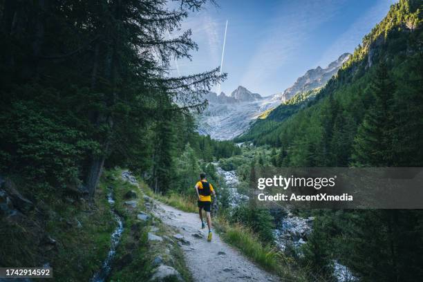 trail runner bounds along mountain trail - mont blanc massif stock pictures, royalty-free photos & images