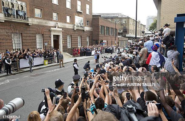 The crowd stretch out to capture pictures as Prince William and Catherine, Duchess of Cambridge show their new-born baby boy to the world's media...