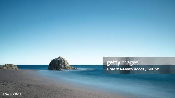 scenic view of beach against clear blue sky - roca stock pictures, royalty-free photos & images