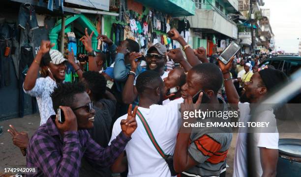 Supporters of Liberia's CDC ruling party react in Monrovia on October 24, 2023 as official results show current President George Weah as the winner...