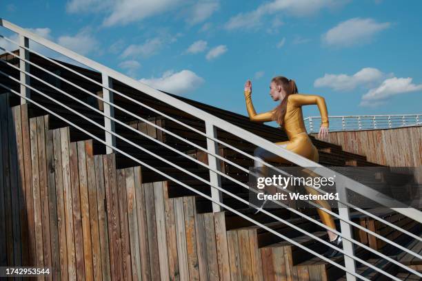 woman running on steps at sunny day - bodysuit stock pictures, royalty-free photos & images