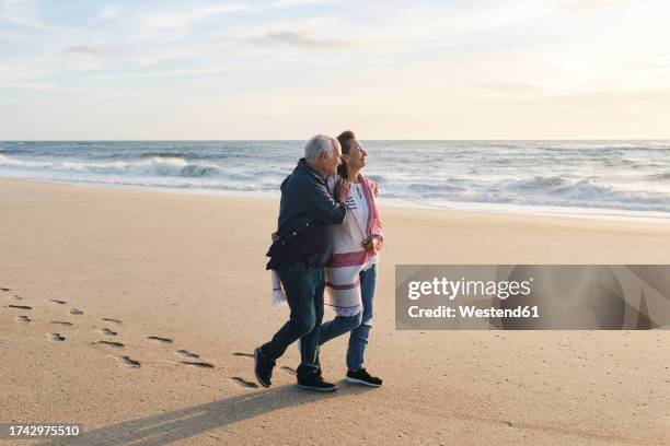 loving senior couple walking on sand at beach - westend 61 fotografías e imágenes de stock