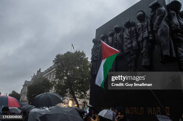 Hundreds of people brave the rain to join a vigil for the victims of the al-Ahil Hospital attack at 10 Downing Street on October 18, 2023 in London,...