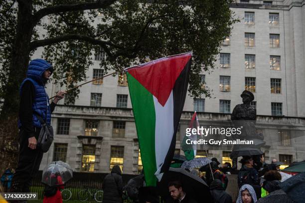 Hundreds of people brave the rain to join a vigil for the victims of the al-Ahil Hospital attack at 10 Downing Street on October 18, 2023 in London,...