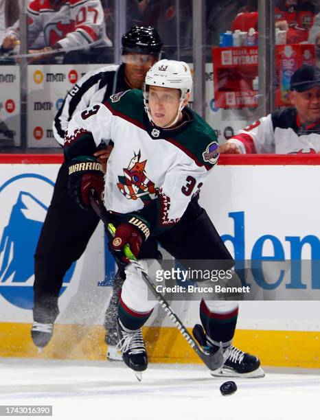 Travis Dermott of the Arizona Coyotes skates against the New Jersey Devils at Prudential Center on October 13, 2023 in Newark, New Jersey.