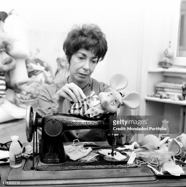 Italian animation artist Maria Perego, inventor of Topo Gigio, laying down a model of the famous puppet on a Singer sewing machine. 1960s.