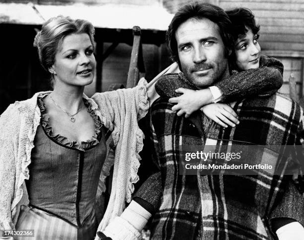 Italian actor Maurizio Merli carrying Matteo Zoffoli piggy-back in the film White Fang to the Rescue. German actress Gisela Hahn watches at them....