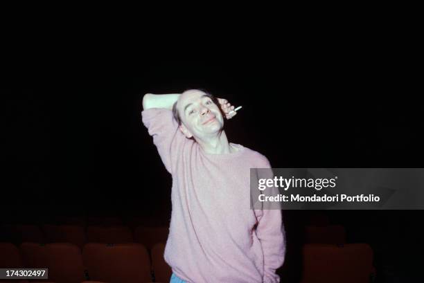 British choreographer, mime and actor Lindsay Kemp smiling smoking a cigarette holding his arm behind his head. 1980s.