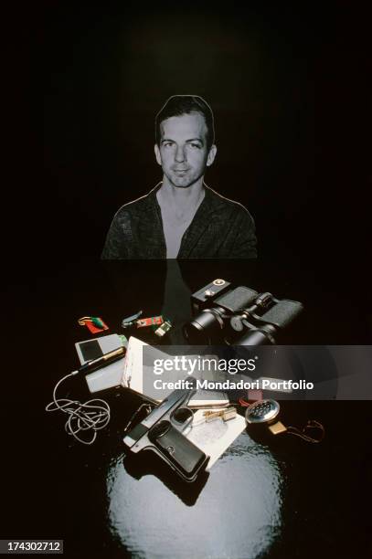 Photo of Lee Oswad used as a background for the equipment donated to American and Soviet spies; a close up of microphones, a rifle, a diary and other...