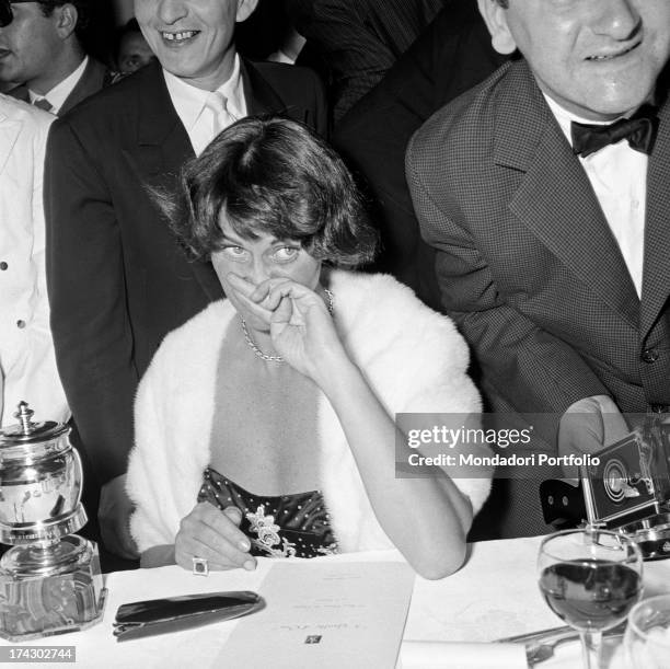 Italian actress Alida Valli sitting at the restaurant on the occasion of Grolla d'Oro Prize 1955. Saint-Vincent, July 1955.