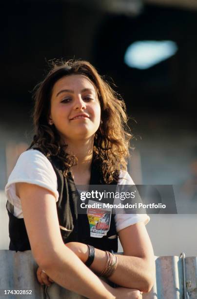 Young woman waiting for Bob Marley's concert at San Siro stadium and smiling. Milan, 27th June 1980.