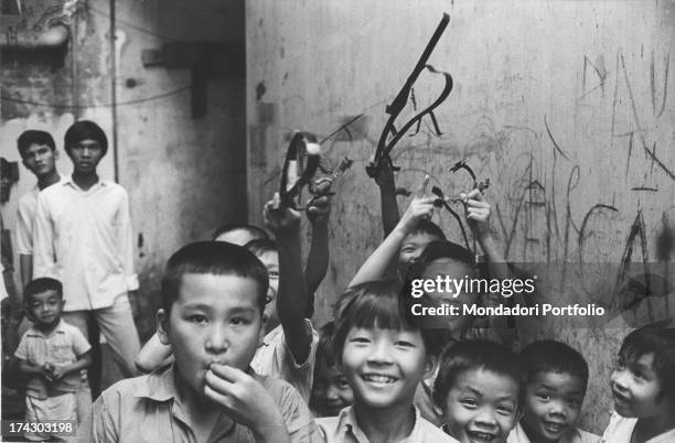 Two Viet Cong prisoners with handcuffs: one is lying and the other is seated. Behind them, three soldiers are making sure the lying man is not dead....