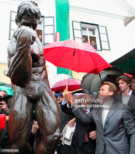Former California Governor Arnold Schwarzenegger and his son Patrick attend on October 7, 2011 the unveiling of a statue during the opening of Arnold...
